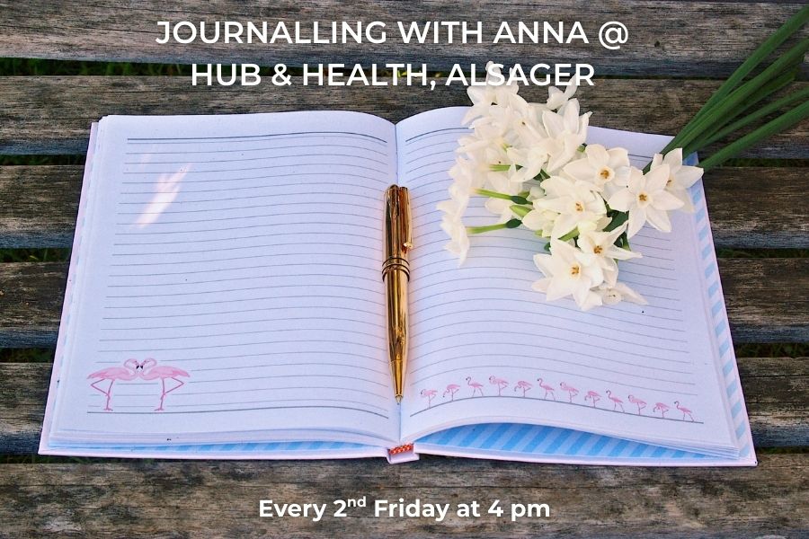 Open notebook with a pen and flowers on a wooden surface, promoting a journalling event at Hub & Health