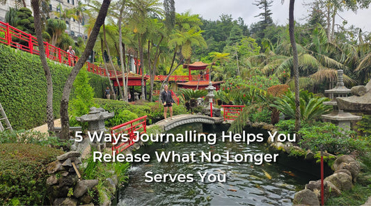 A photograph of a Japanese garden with tall green shrubs and a red painted bridge. Overlay text says '5 Ways Journalling Helps You Release What No Longer Serves You'